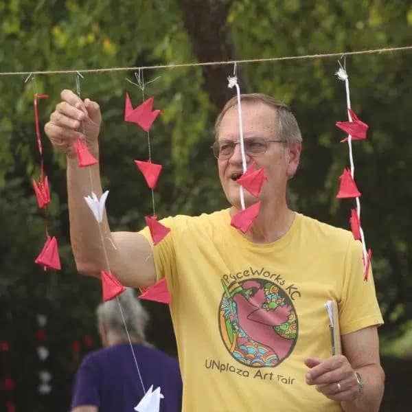 Man hanging origame peace cranes.